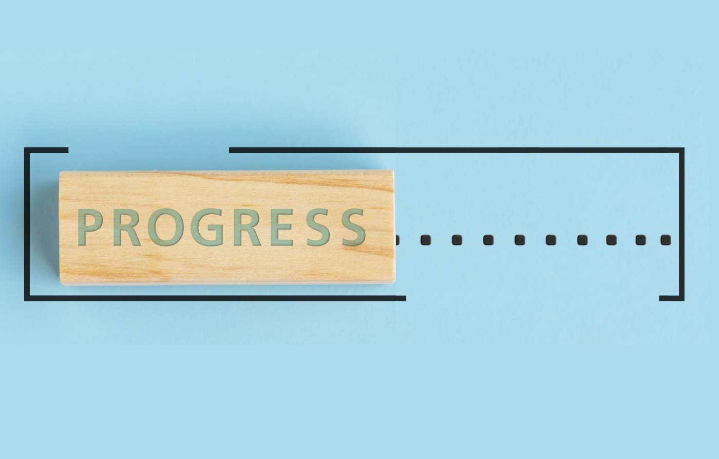 Ein Holzstück, in das "Progress" eingraviert ist.