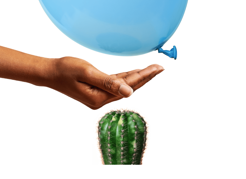 Ein Luftballon schwebt über einer Handfläche, die wiederum über einem Kaktus gehalten wird.